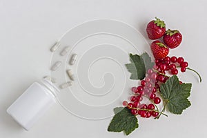 Vitamins supplements as a capsule with fresh berries from the medicine jar on white background