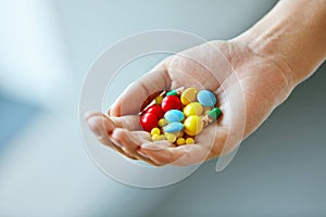 Vitamins And Supplements. Female Hand With Colorful Pills