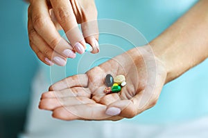 Vitamins And Supplements. Female Hand Holding Colorful Pills