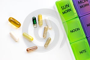 Vitamins on white background with pill colorful pill case