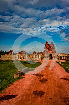 Vithala temple with leading red soil road and amazing blue sky at hampi ruins