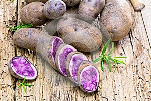 Vitolette noir or purple potato. On a wooden table.