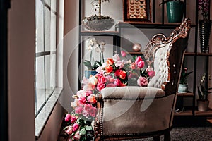 A vitrine from a flower shop with chair and flowers photo