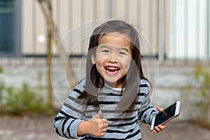 Vivacious playful little girl giving a thumbs up