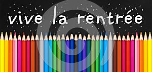 Vive la rentree meaning Back to school written on black chalkboard with colorful wooden pencils photo