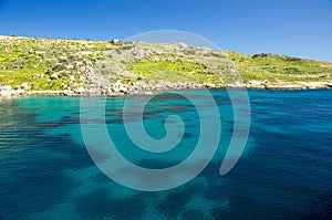 Vivid blue water in harbour near town Mgarr in Gozo island, Malt