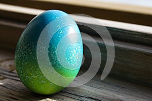 Vivid colored egg abandoned on window