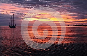 Vivid crimson clouds and sky sunrise seascape with water reflect