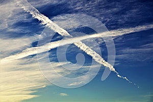 Vivid Crossed Jet Streams in Clouded Blue Sky