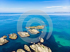 Vivid emerald-green water at Ballintoy harbour along the Causeway Coast in County Antrim. Rugged coast of Northern Ireland