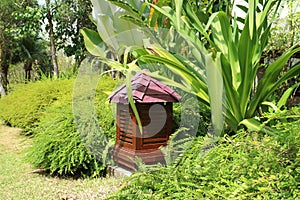 Vivid green tropical garden with red brown garden lamp, Thailand