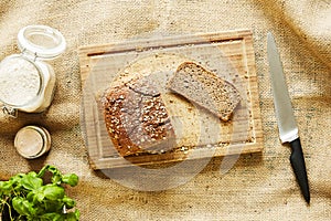 Vivid kitchen scenery slicing bread on wooden cutting board