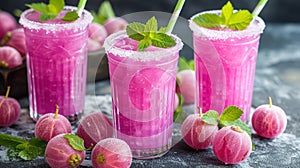 Vivid pink gooseberry juice with mint and ice for summer refreshment.