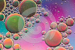 Vivid purple, pink, orange and green psychedelic abstract giving the impression of planets