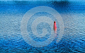 Vivid red buoy on river surface background