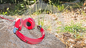 Vivid red wired headphones on the stone