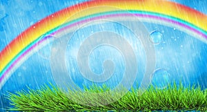 Vivid spring landscape with rainbow and green grass