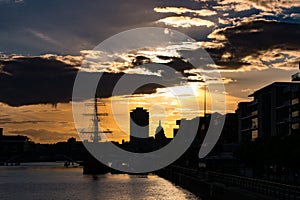 Vivid Sunset in Dublin, Ireland looking over River Liffey with buildings and Dublin Spire in silhouette