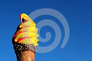 Vivid Yellow Banana with Raspberry Soft Serve Ice Cream Cone Against Sunny Blue Sky