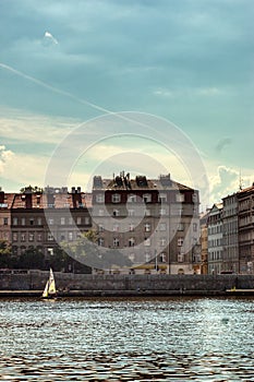 Vlatava shores with boat and houses with clouds in Prague