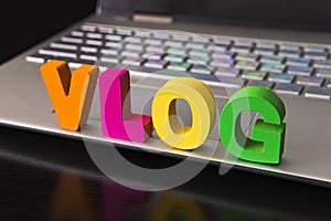 Vlog or video blog concept with vlog word from funny letters on background computer keyboard