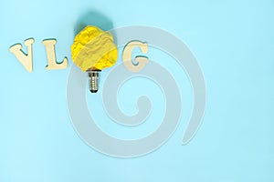 Vlog or vlogging video content innovative trends and ideas concept. Bright yellow crumpled paper light bulb.