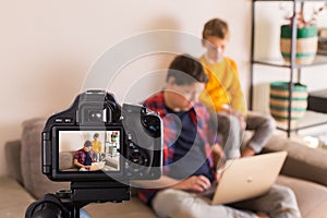 Vlogger family recording social media video while sitting on couch