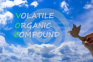 VOC volatile organic compound symbol. Concept words VOC volatile organic compound on beautiful blue sky clouds background. Wooden