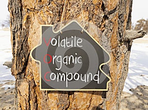VOC volatile organic compound symbol. Concept words VOC volatile organic compound on beautiful yellow blackboard. Beautiful tree photo