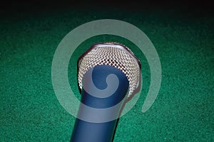 Vocal microphone on a background of green cloth close-up