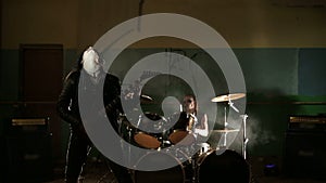 Vocalist and drummer of black metal band at dark background