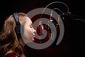 Vocalist singing in studio. School and vocals. Against the backdrop of red smoke