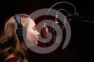 Vocalist singing in studio. School and vocals. Against the backdrop of red smoke photo