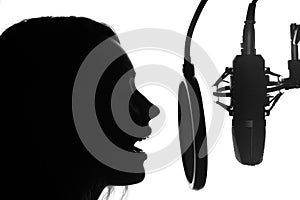 Vocals with studio microphone, silhouette. Black and white photo