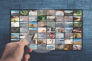 VOD service on television. TV streaming concept. man holding remote control with many icons of video service on demand on