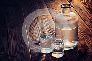 Vodka bottle and two glasses of vodka with ice on a table