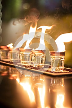 Vodka fire shots lined up on a table in a bar