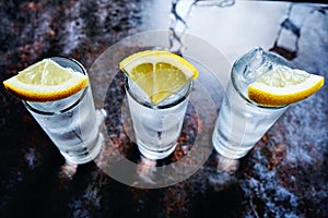 Vodka or gin or tequila in shot glasses on stone table