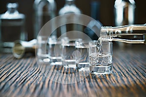 Vodka pouring from the bottle into glass in a bar, selective fo