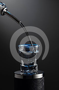 Vodka pouring from the bottle into a glass on a dark background