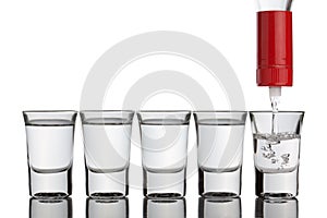 Vodka pouring into shot glasses standing in row.