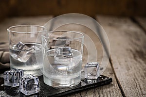 Vodka in shot glasses on rustic wood background