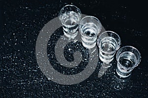 Vodka. Shots, glasses with vodka with ice .Dark background. Copy space .Selective focus.