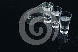 Vodka. Shots, glasses with vodka with ice .Dark background. Copy space .Selective focus.