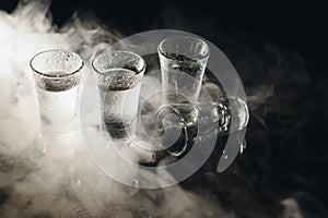 Vodka. Shots, glasses with vodka with ice .Dark background. Copy space .Selective focus.