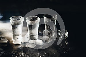 Vodka. Shots, glasses with vodka with ice .Dark background. Copy space .Selective focus.