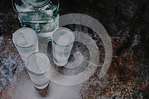 Vodka. Shots, glasses with vodka with ice .Dark stone background.Copy space .Selective focus