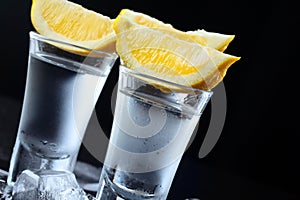 Vodka. Shots, glasses with vodka with lemon.Dark stone background.Copy space .Closeup.Selective focus