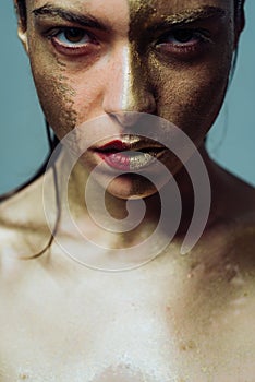 Vogue concept. Golden skin. Attractive woman pretty face with makeup and body art metallized color. Spa and wellness