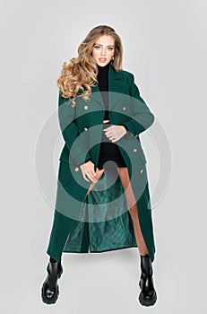 Vogue female coat. High fashion portrait of young elegant woman in studio. Fashion model, beautiful young woman posing